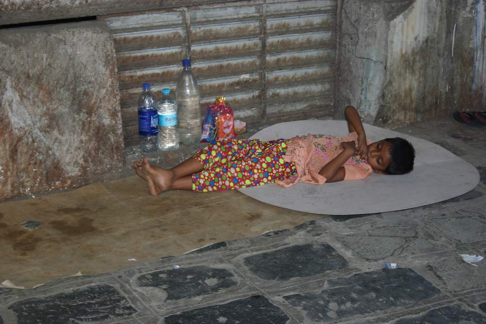 Nach harter Arbeit: Kind schläft in Mumbai (Bombay) auf der Straße im Stadtteil Fort