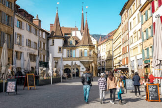 Familie spatziert durch die Altstadt von Neuenburg auf der Schnitzeljagd "Les Chenapans" in der Altstadt von Neuhchatel.