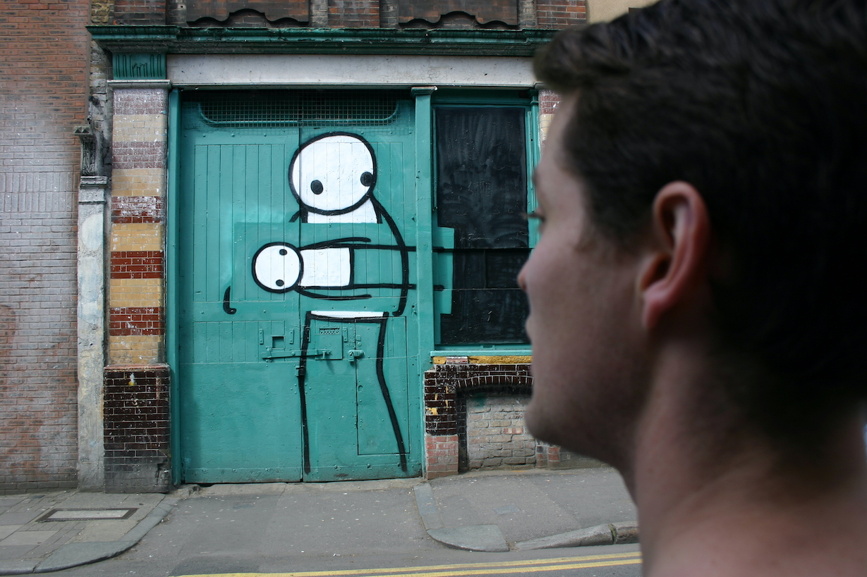 Streetart-Tourist betrachtet Kunstdiebe von Stik in Hackney